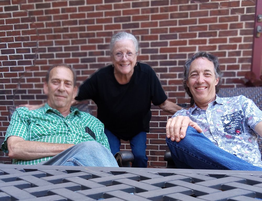 Tom Spaeth, right, relaxing and smiling with family on a brick patio