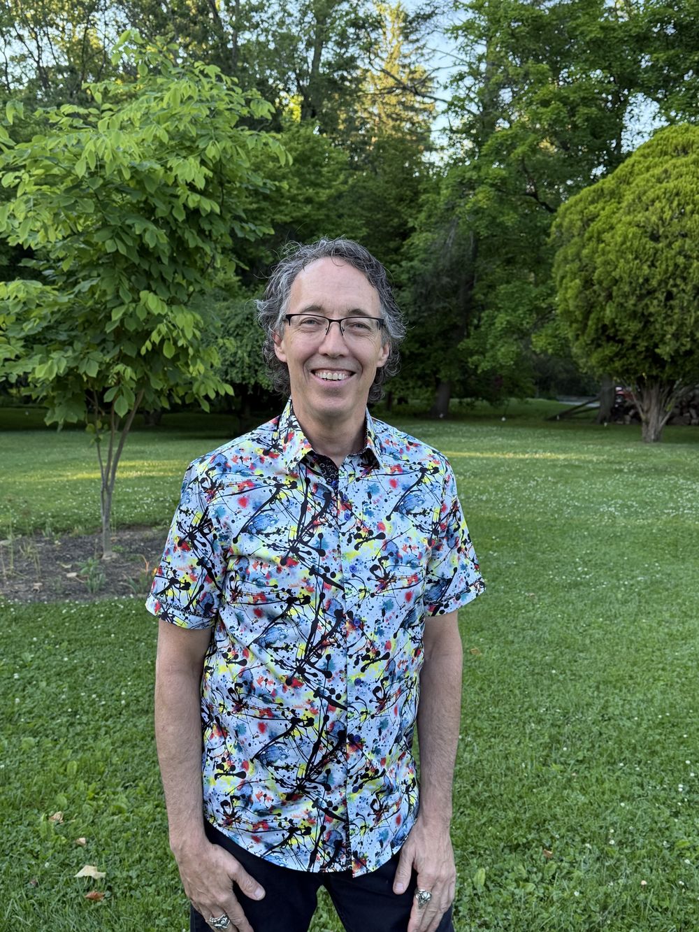 Tom Spaeth, founder of Doulos Impact Group, smiling outdoors on a summer evening